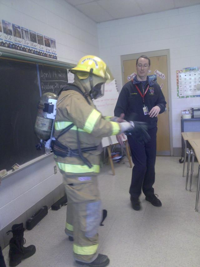 Paramedic Firefighter Scott Lindberg and Firefighter Kevin Younkins show the 4th graders  what a firefighter looks like all dressed up